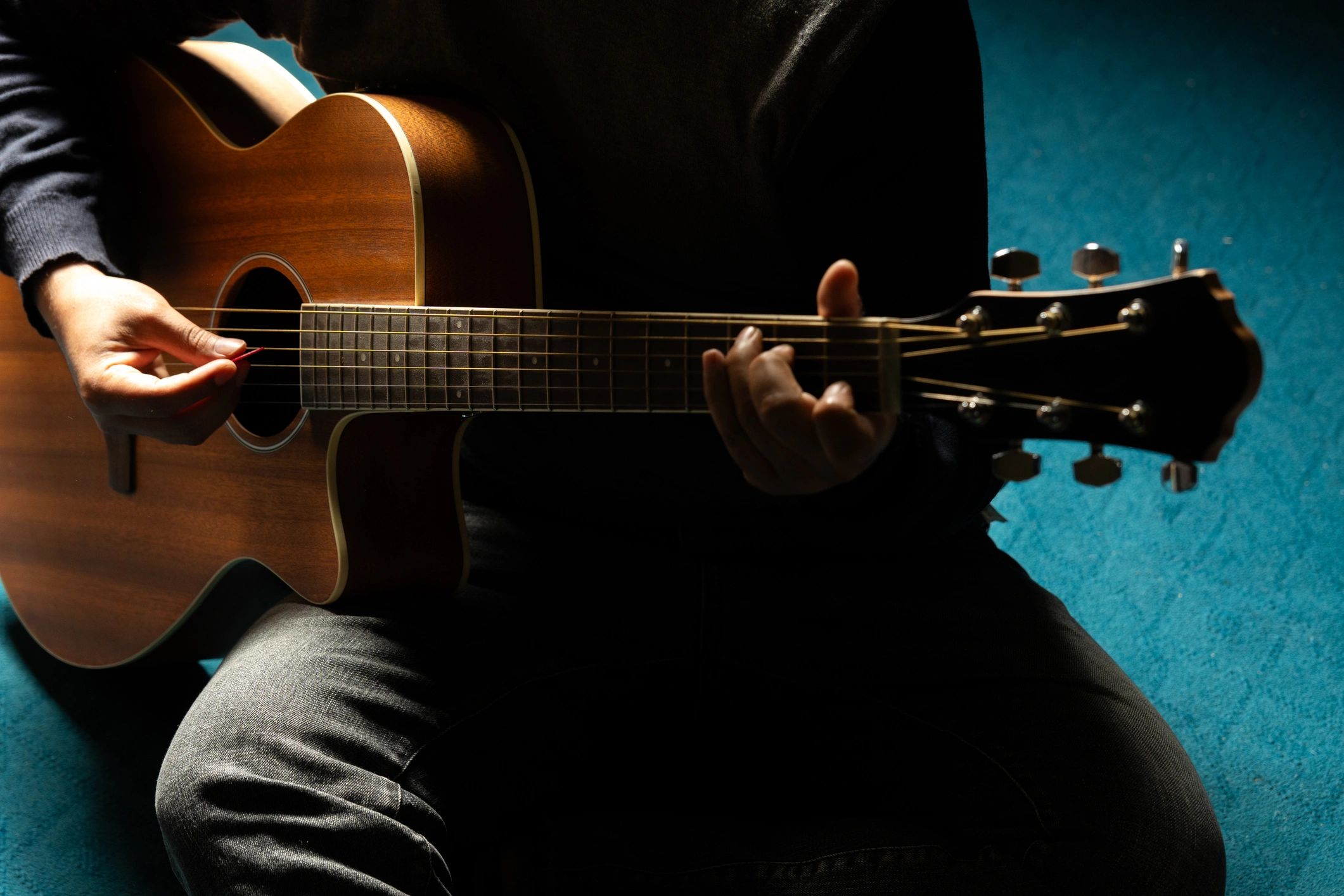 Acoustic guitarist in a dimly lit room