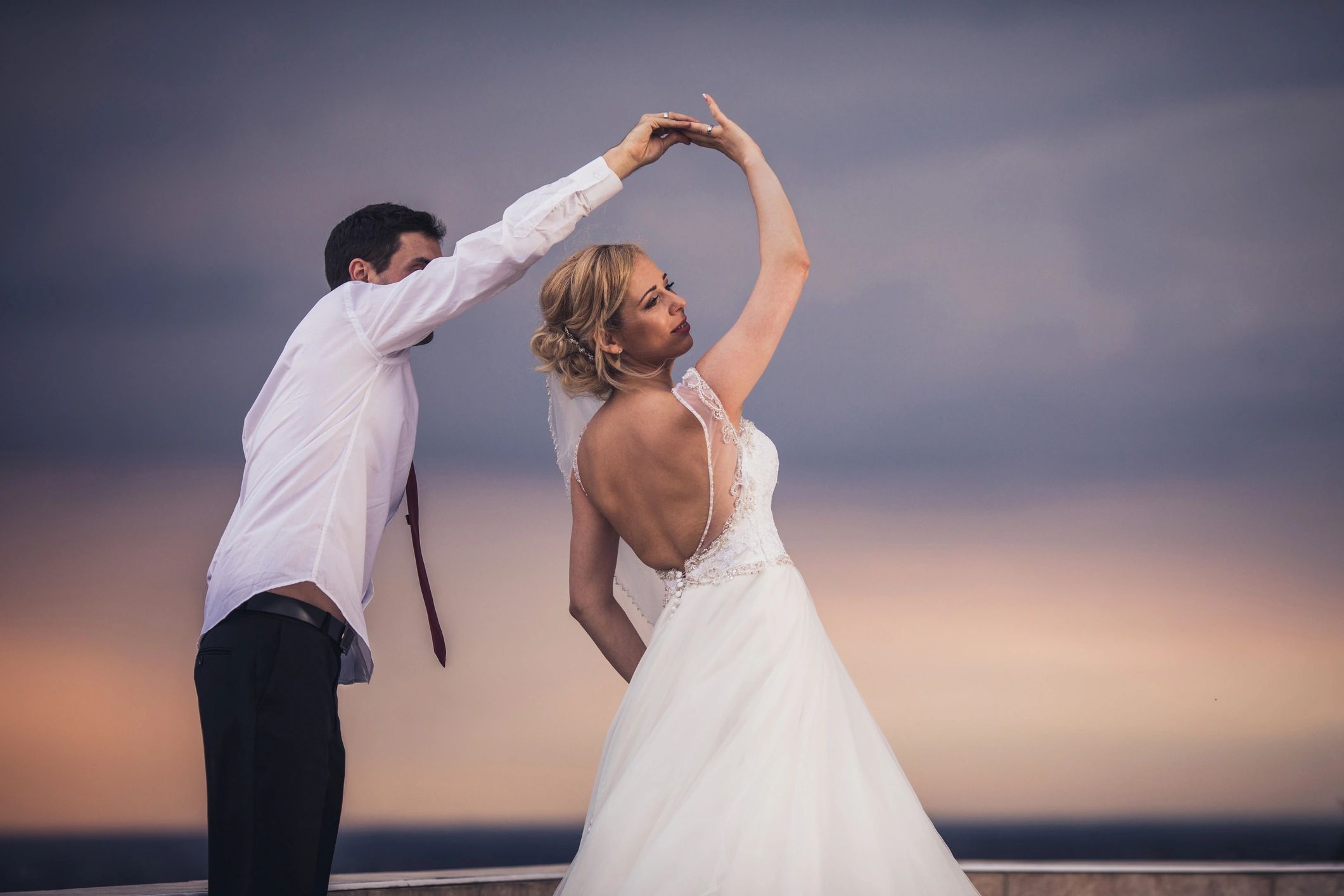 Bride and groom dancing outdoors at sunset